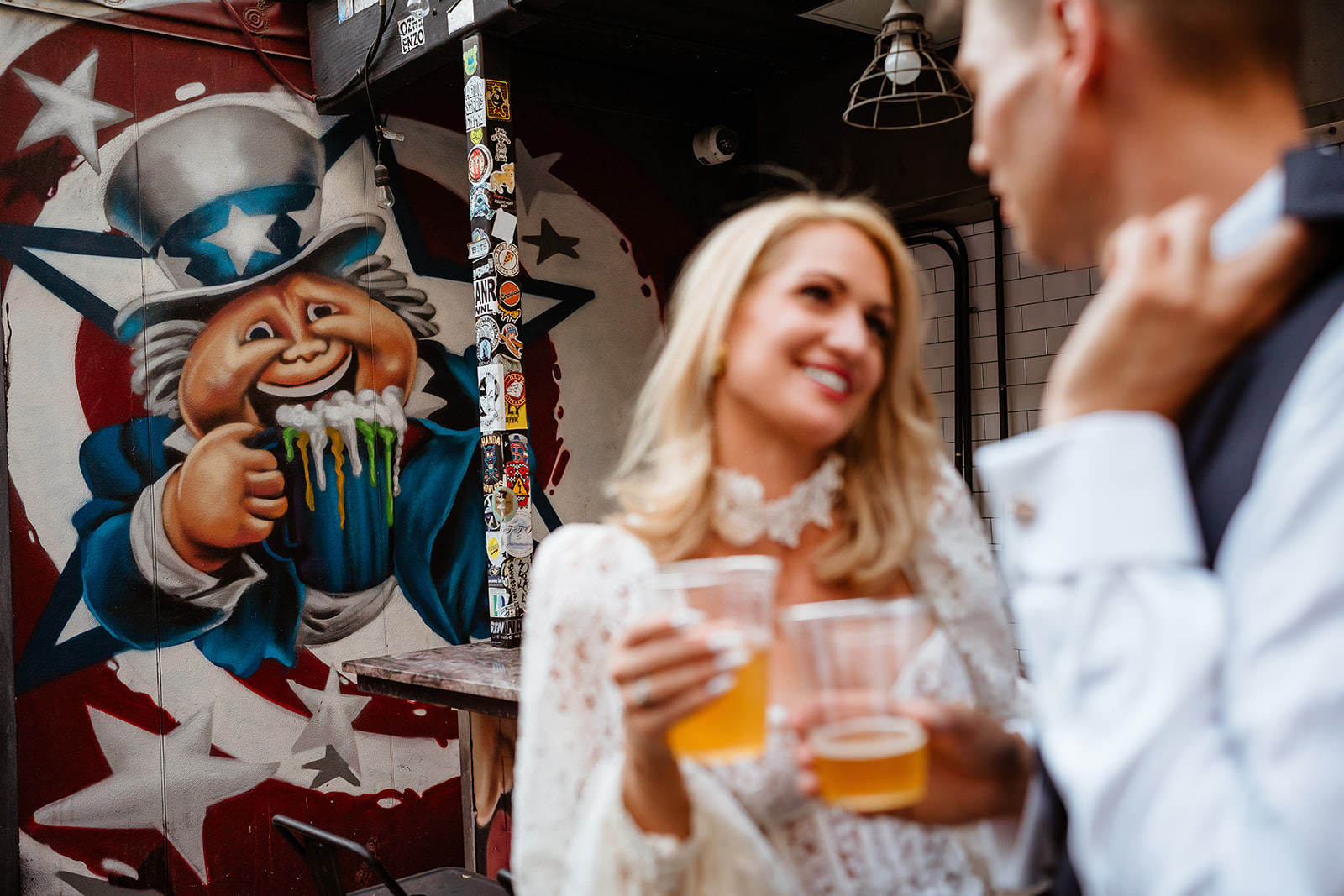 wedding couple having drinks at a downtown Las Vegas bar with mural in background