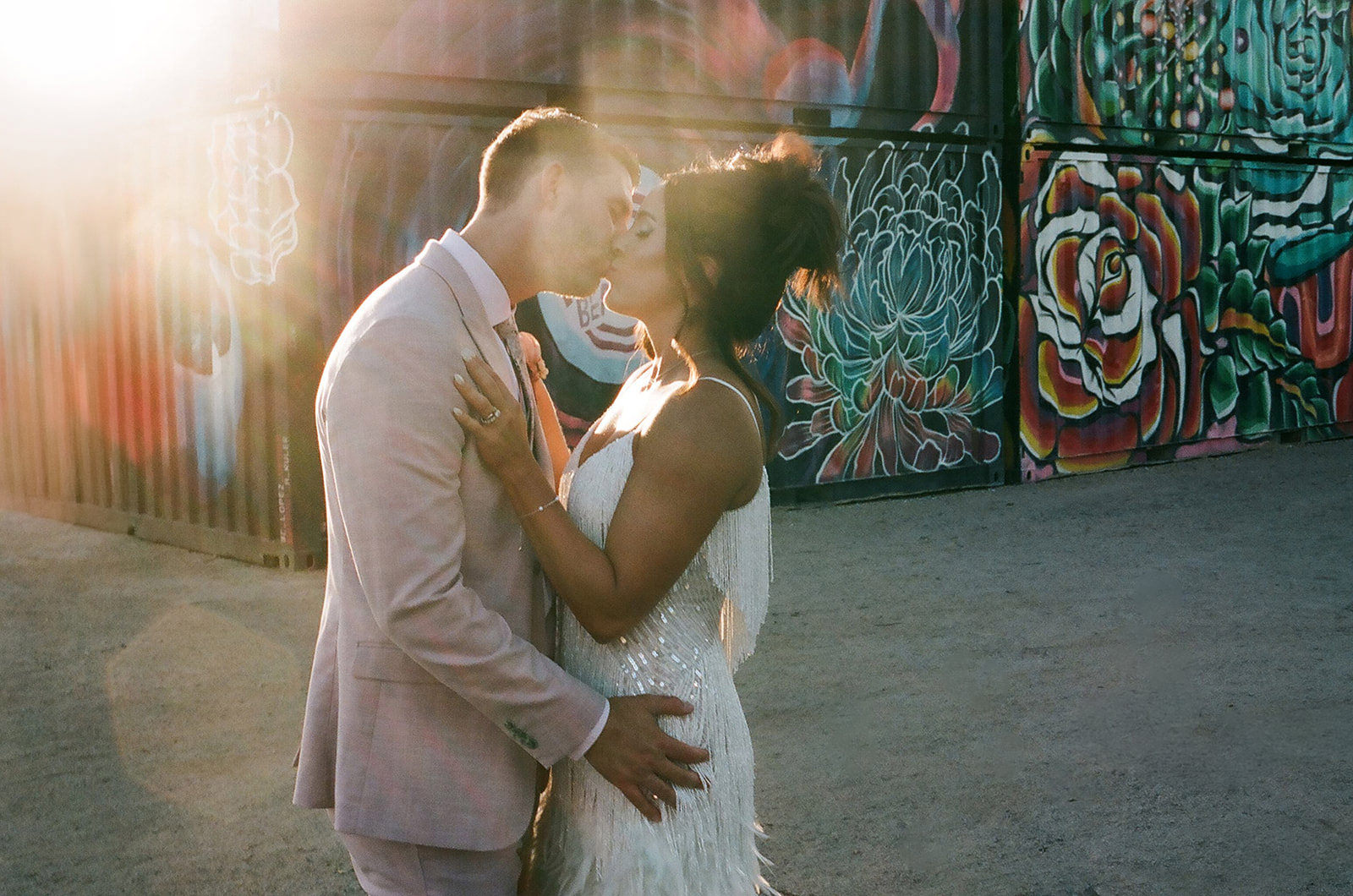 wedding couple kissing at sunset in downtown Las Vegas with colorful mural background