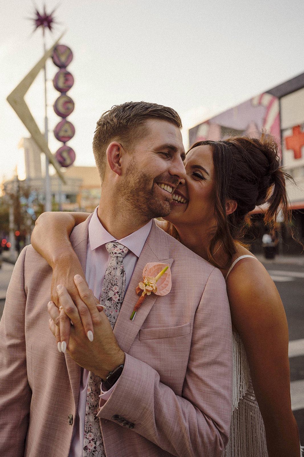 close-up of wedding couple embracing with Las Vegas neon sign in background