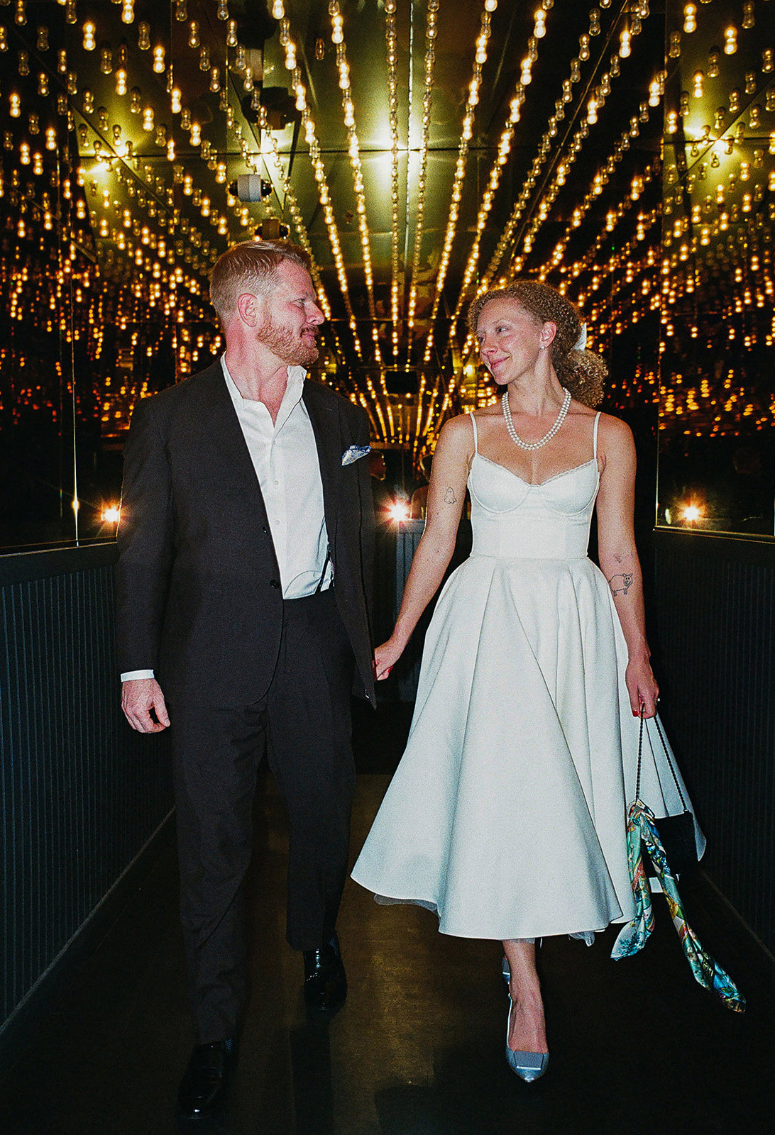 Las Vegas elopement couple walking under neon lights at night, cinematic wedding photo