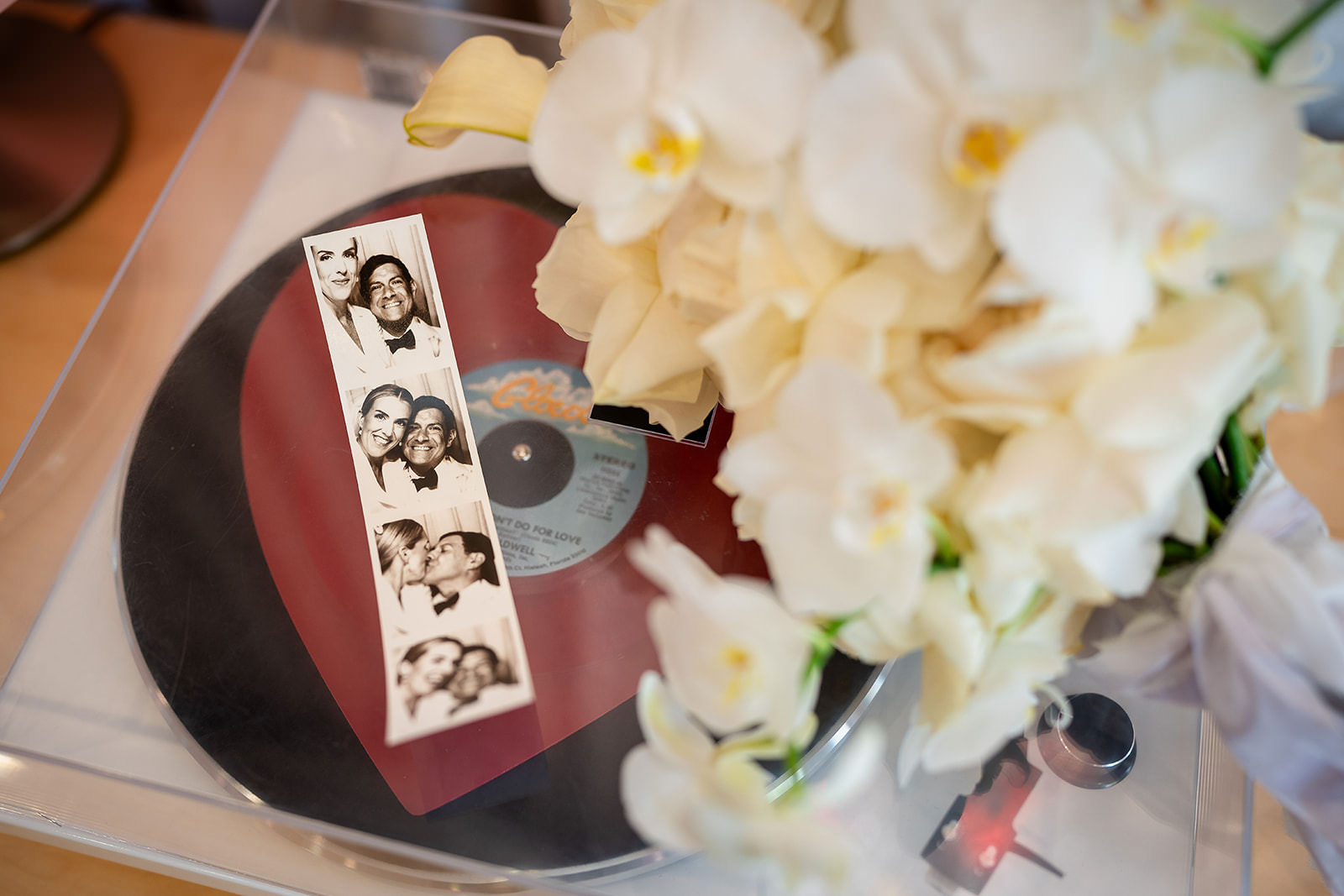 Las Vegas elopement details with vinyl record, photo booth strip, and white flowers