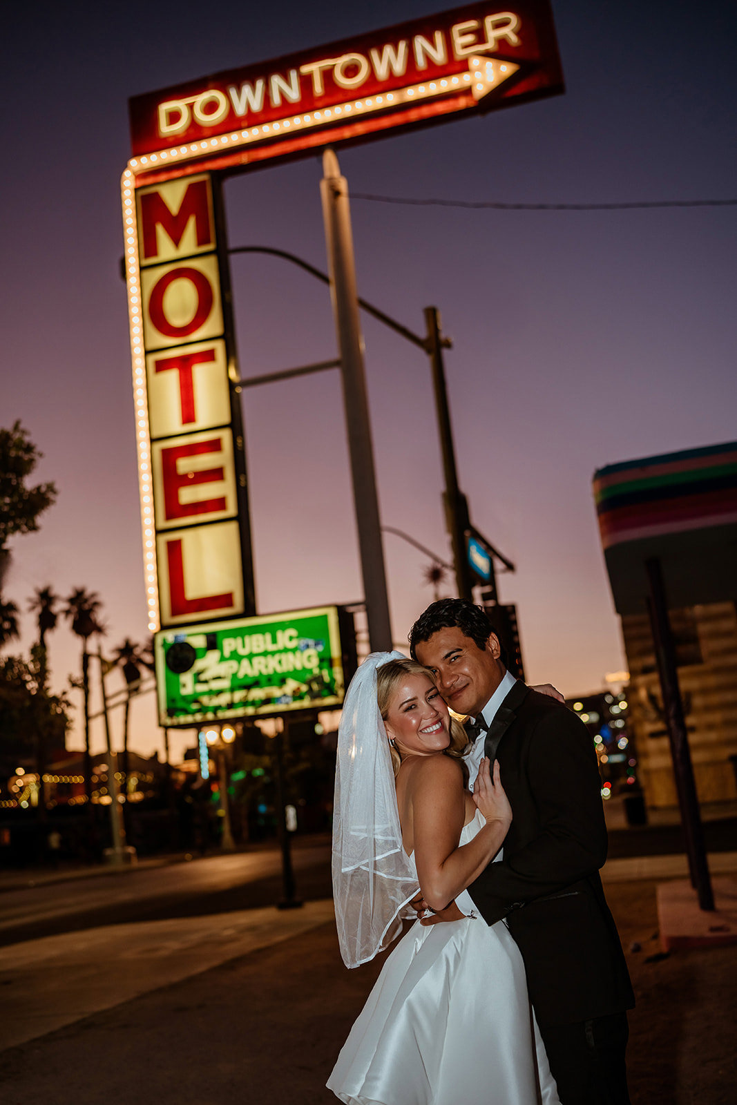 wedding couple embracing under Downtowner Motel neon sign in downtown Las Vegas at sunset