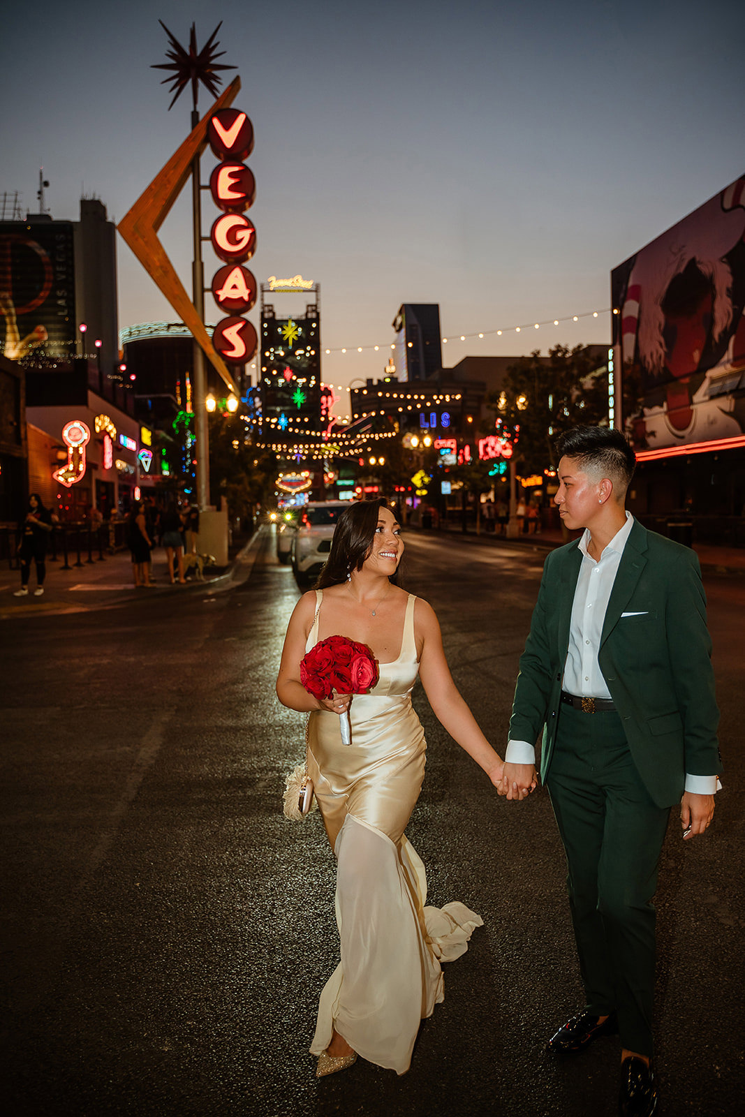 wedding couple walking on Fremont Street Las Vegas at night after elopement