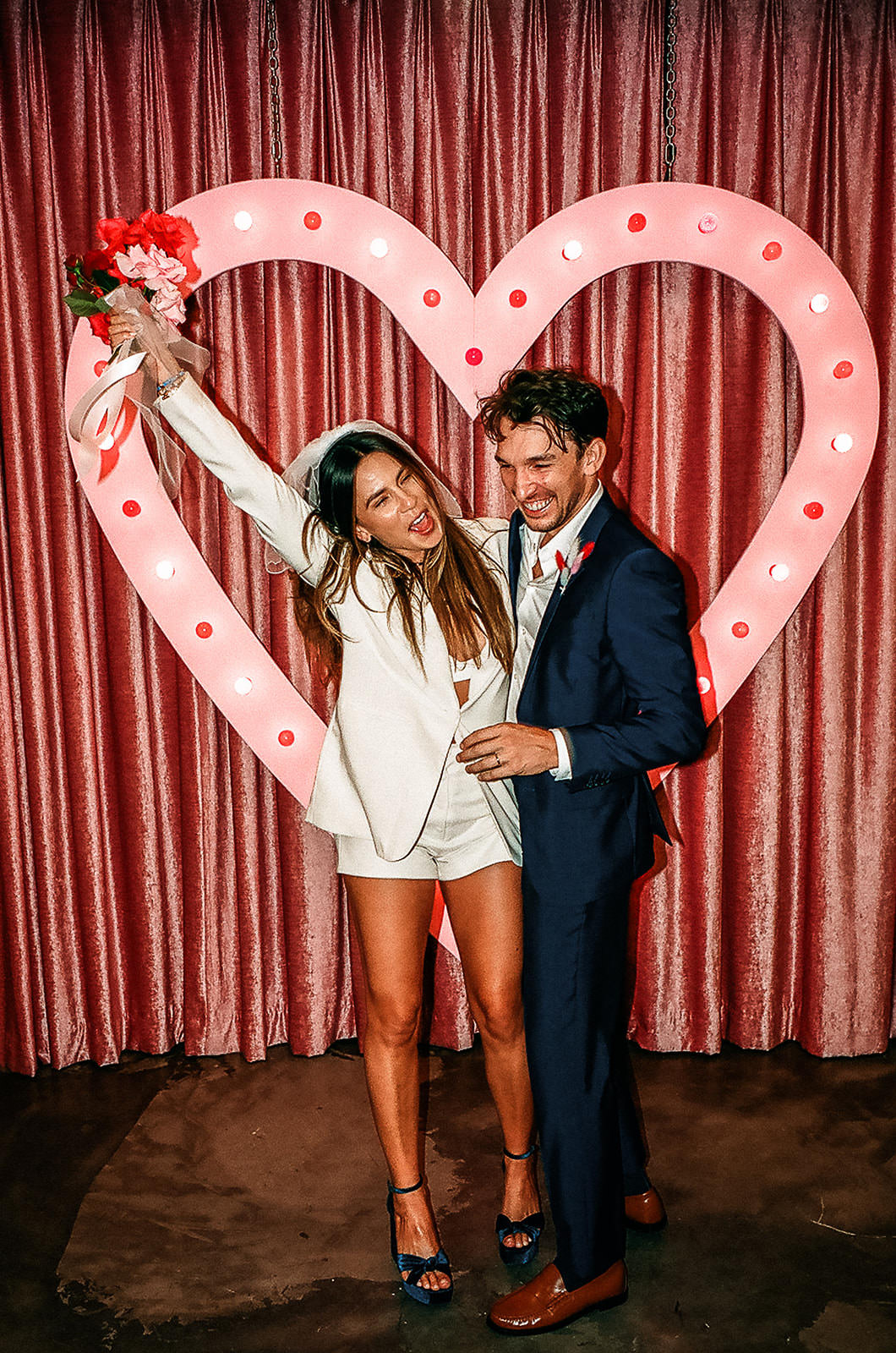 fun wedding couple celebrating in front of heart altar at Sure Thing Chapel Las Vegas