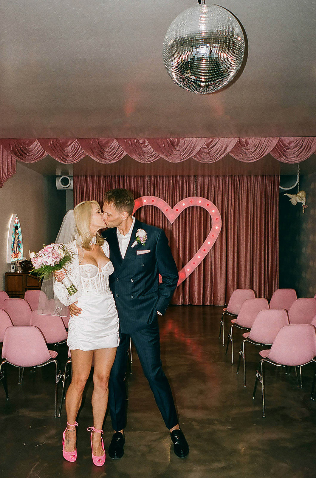 couple kissing inside Sure Thing Chapel Las Vegas heart altar wedding portrait with disco ball