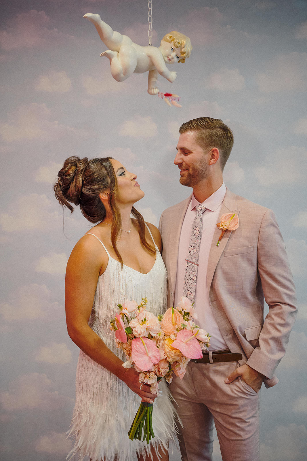 couple portrait under cherub backdrop at Sure Thing Chapel Las Vegas elopement
