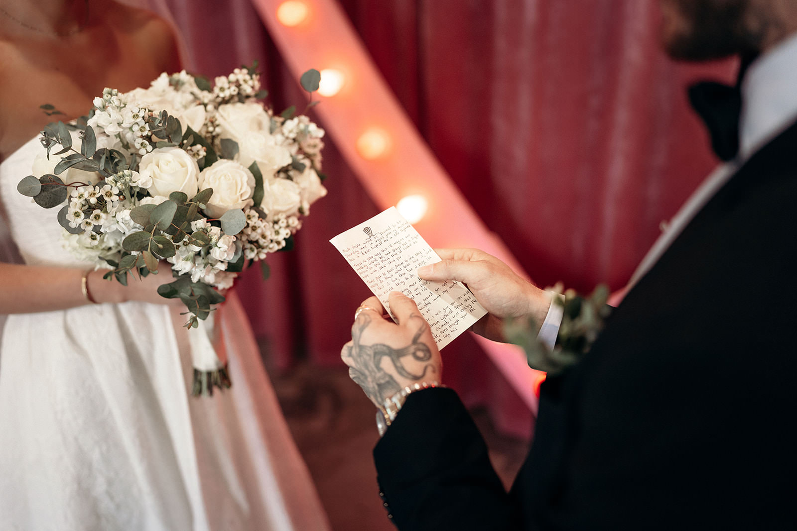 groom reading wedding vows during ceremony at Sure Thing Chapel Las Vegas with bride holding bouquet