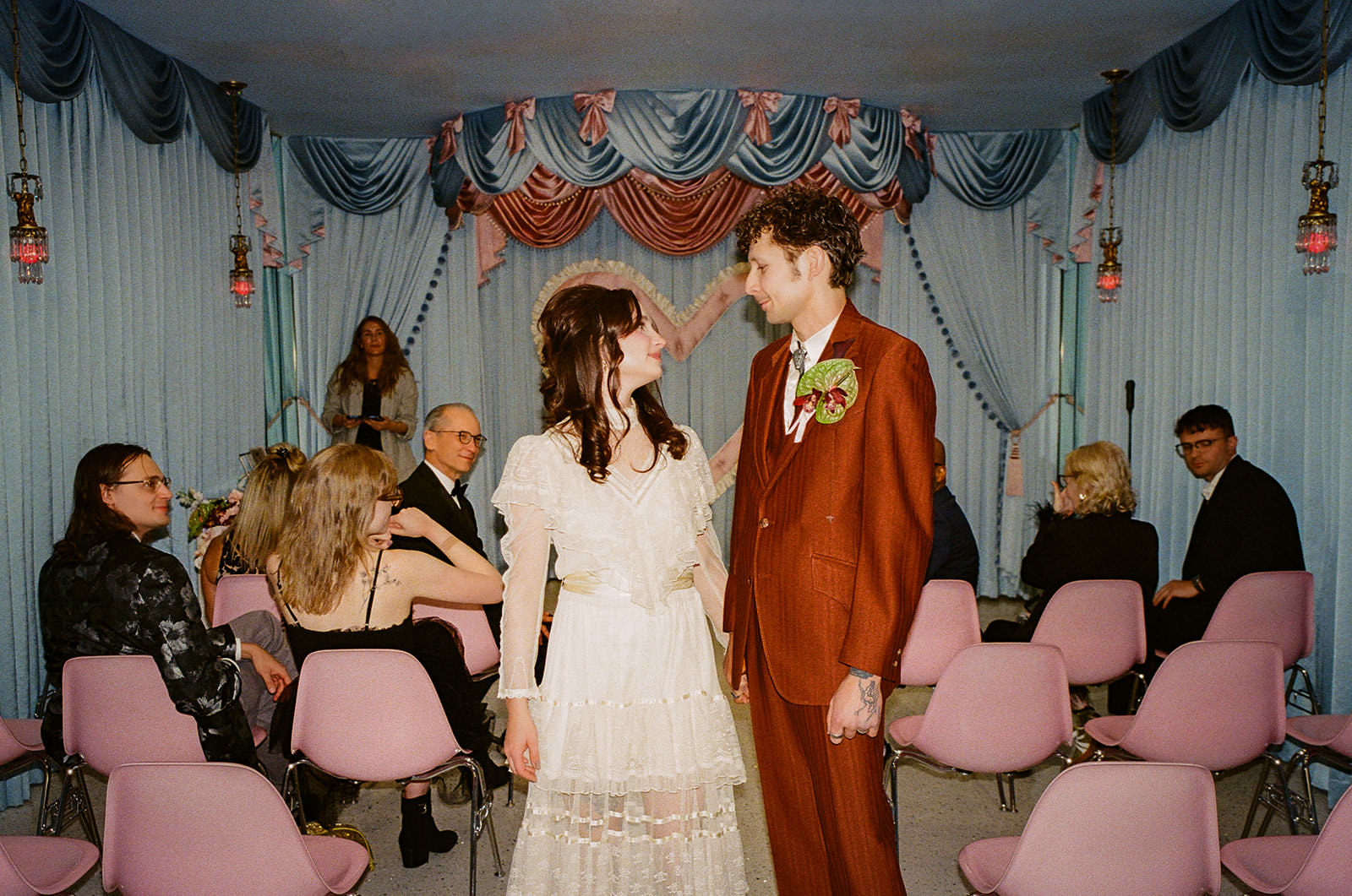 couple standing together during wedding ceremony at Sure Thing Chapel Las Vegas with guests and heart altar